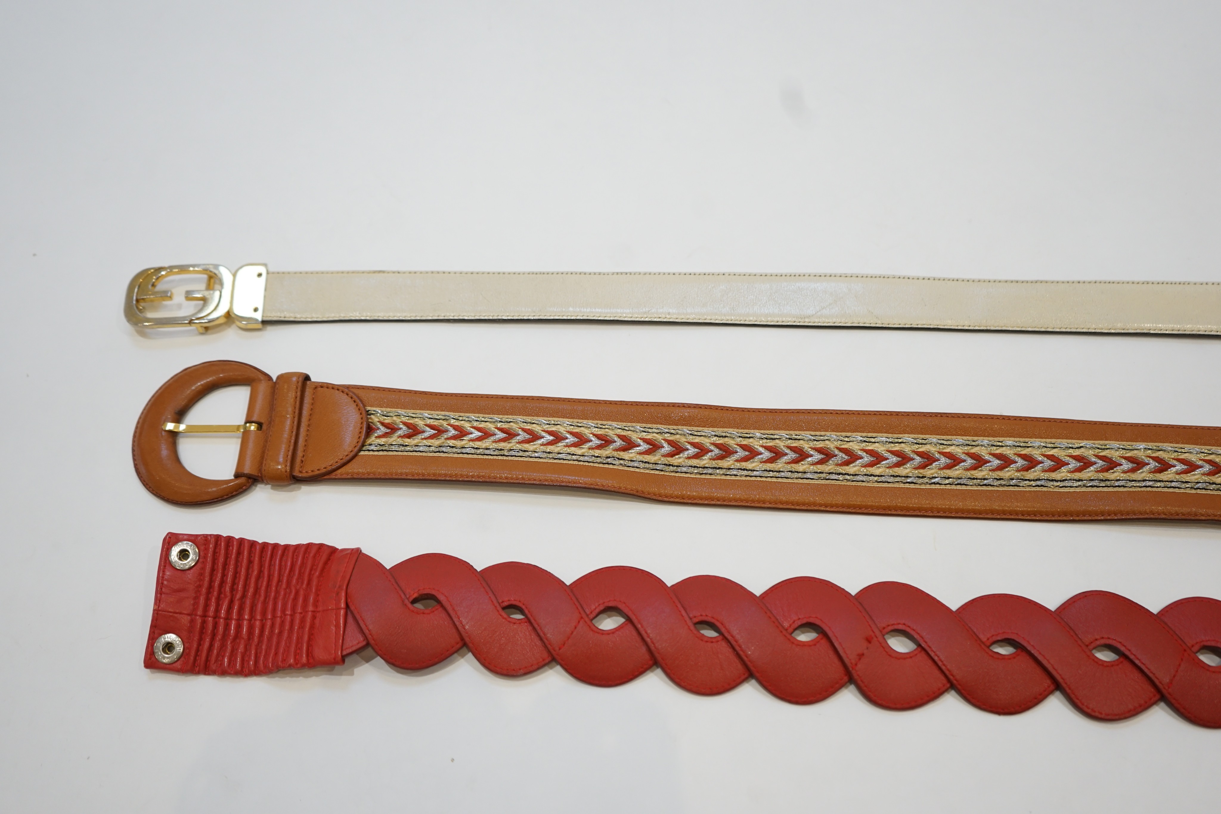 A Gucci cream leather belt and two Valentino belts